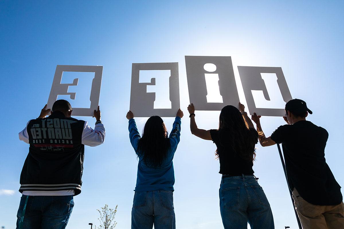 Group of students holding up cut out letters of L I F E